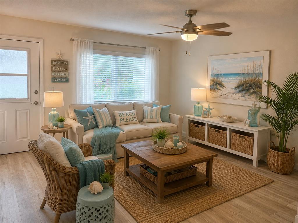 A coastal-themed living room features a beige sofa, wicker armchair, wooden coffee table, and area rug — 8080 112TH STREET UNIT 107, SEMINOLE, FL