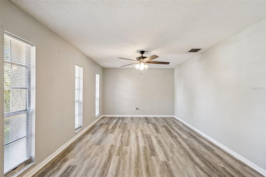 A living room with light gray walls, tile flooring, a ceiling fan, and three windows — 4035 WENDY DRIVE, ORLANDO, FL