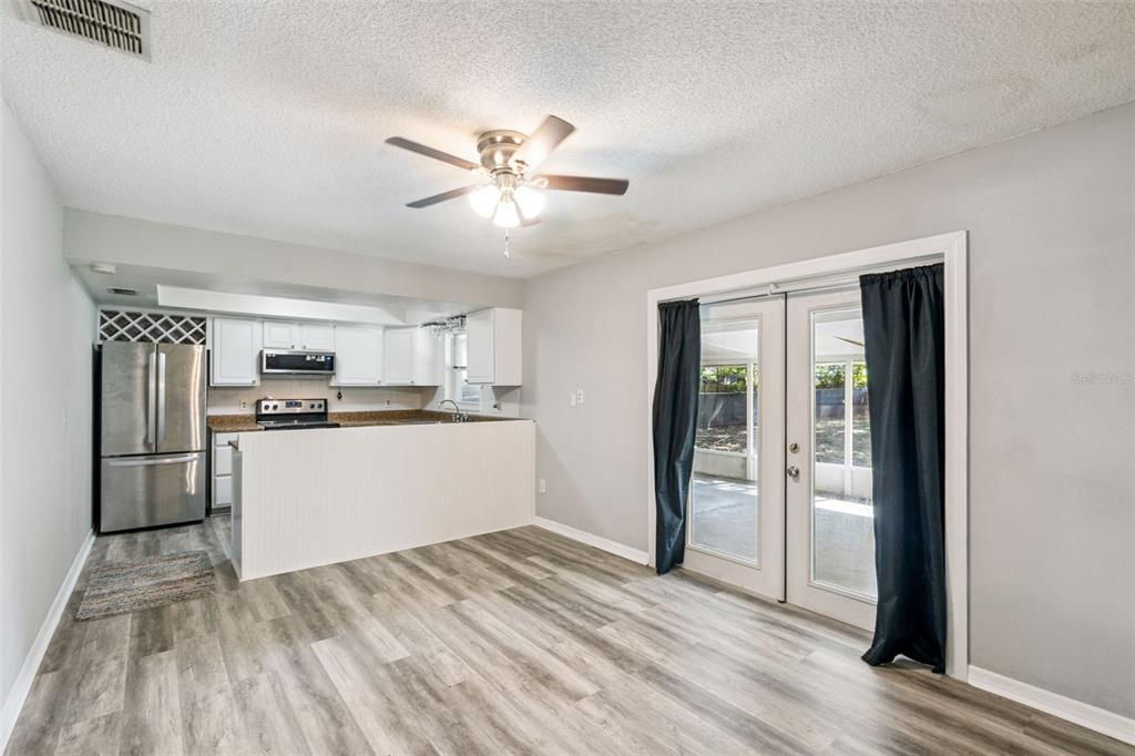 A kitchen features wood cabinets, granite countertops, a stainless steel microwave, and a window — 4035 WENDY DRIVE, ORLANDO, FL