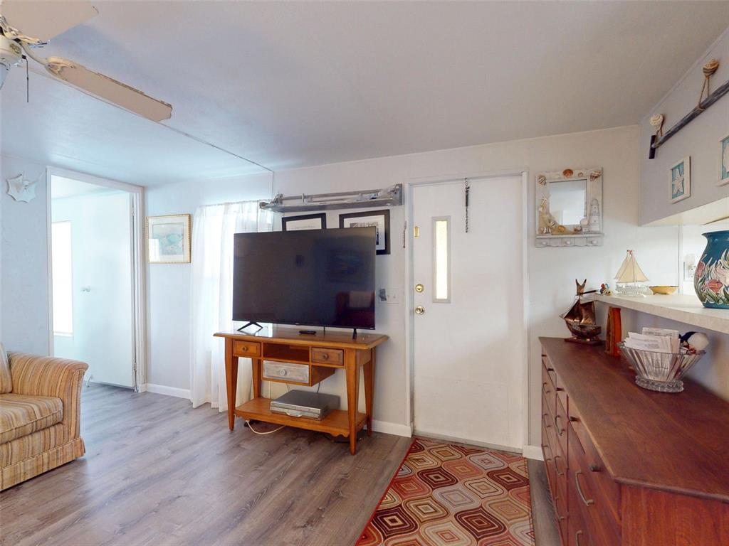 A wooden dresser sits in a living area next to a kitchen and dining space — 2201 S RIDGEWOOD AVENUE UNIT 8, EDGEWATER, FL