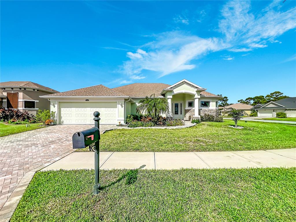 A kitchen with white cabinets and granite countertops opens to a dining area with chairs — 2595 JOLENA DRIVE, MELBOURNE, FL