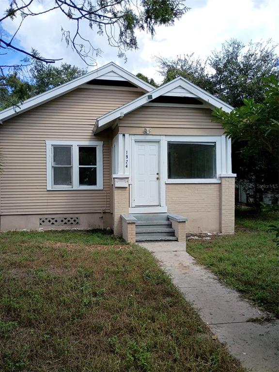 A concrete driveway leads to the side entrance of a house with gray steps — 1924 30TH STREET S, ST PETERSBURG, FL