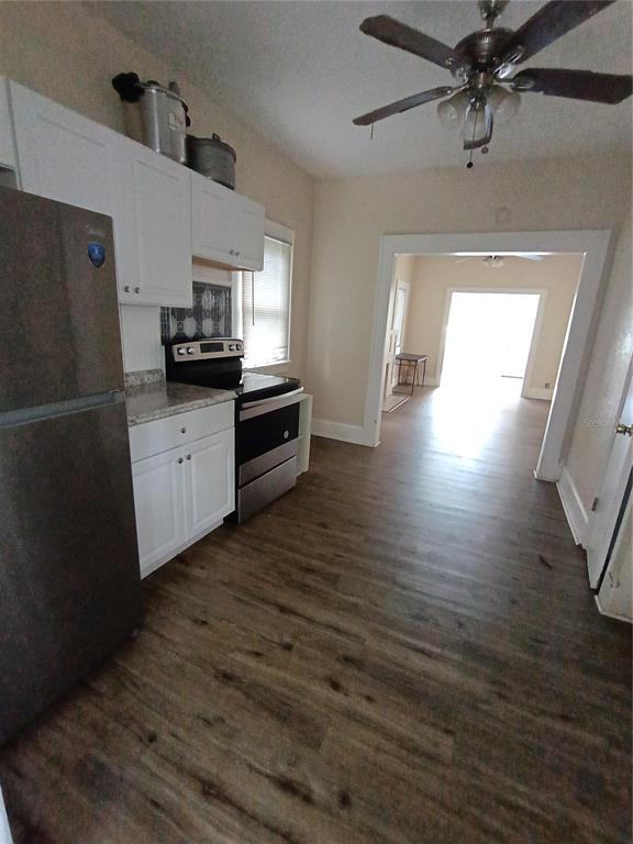 An interior view shows a living room with wood-look flooring leading to a fireplace area — 1924 30TH STREET S, ST PETERSBURG, FL