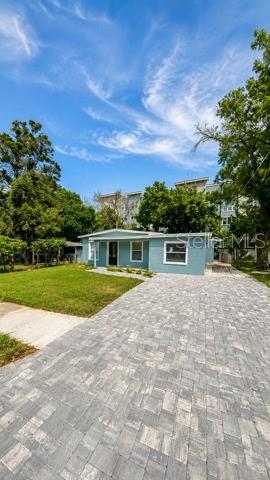 An empty bedroom features light wood-look flooring, gray walls, a ceiling fan, and a wall-mounted television — 4307 W MAIN STREET, TAMPA, FL