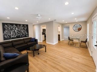 A bedroom features a bed with patterned bedding, two lamps, a floor mirror, and wood flooring — 4307 W MAIN STREET, TAMPA, FL