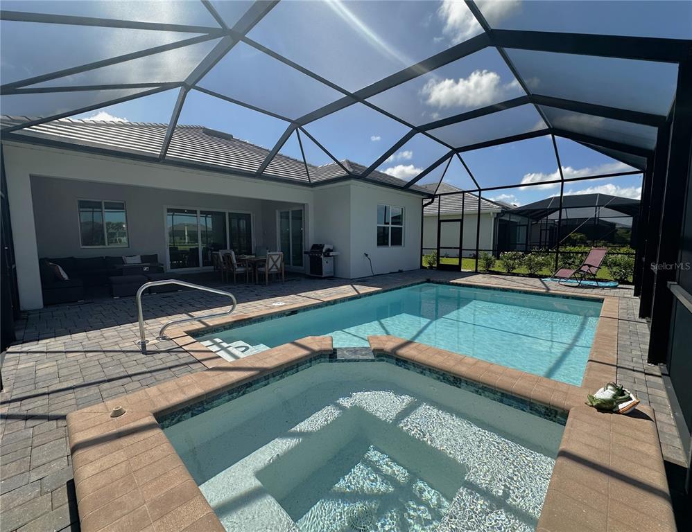 A screened-in patio features a swimming pool, a hot tub, and outdoor seating — 15172 RIVER BIRCH COURT, PUNTA GORDA, FL