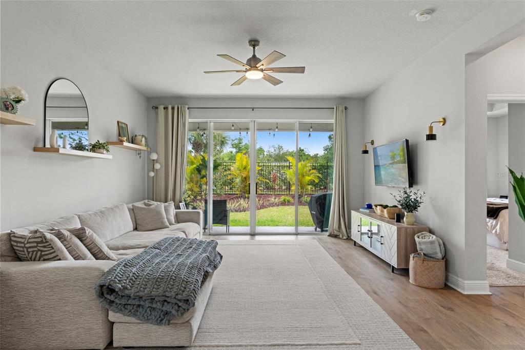 A dining area with a wooden table and chairs sits adjacent to an open living room — 5607 DEL CORONADO, APOLLO BEACH, FL