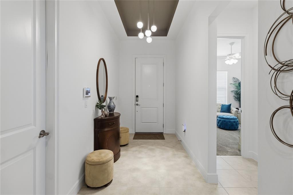 A bright entryway features a dark ceiling inset, pendant lighting, tile floors, and a console — 5003 DANCY LANE, ST CLOUD, FL