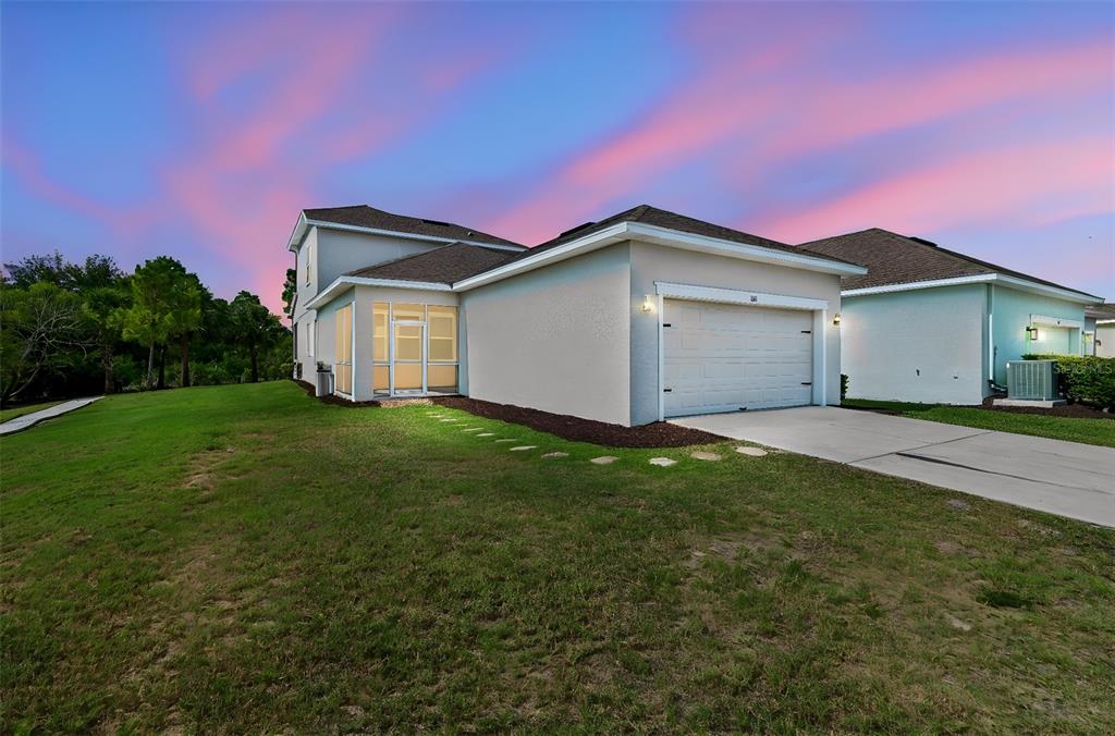 A side view of a two-story house with a garage and a screened-in porch — 803 WINTERSIDE DRIVE, APOLLO BEACH, FL