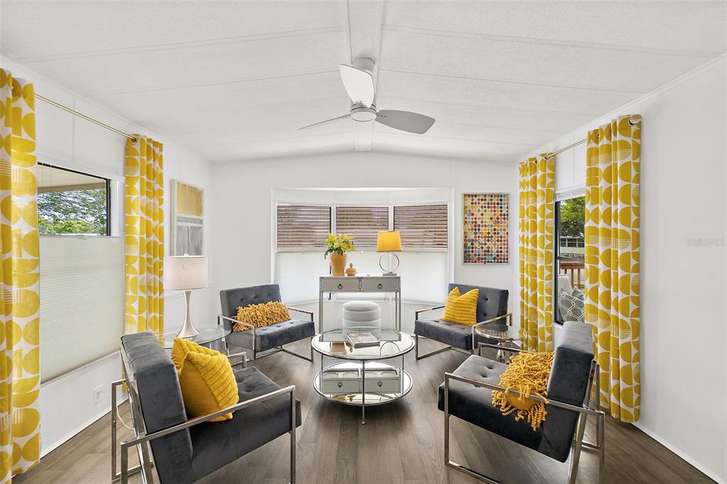 A living room features gray velvet chairs, a glass coffee table, and yellow patterned curtains — 727 ROLLING HILLS DRIVE, PORT ORANGE, FL