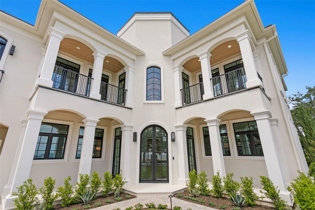 The exterior of a two-story white stucco house features arched balconies and a central entrance — 3907 BAYSHORE BOULEVARD, TAMPA, FL