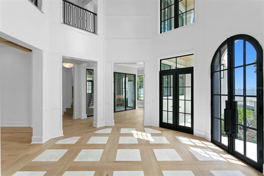 A bright foyer features white walls, a patterned wood and tile floor, and black-framed doors — 3907 BAYSHORE BOULEVARD, TAMPA, FL