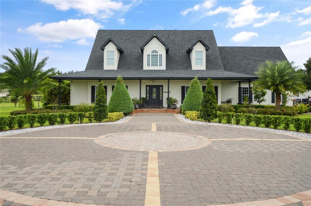 A two-story house with a paved circular driveway and three dormer windows on the roof — 2393 APPY LANE, APOPKA, FL