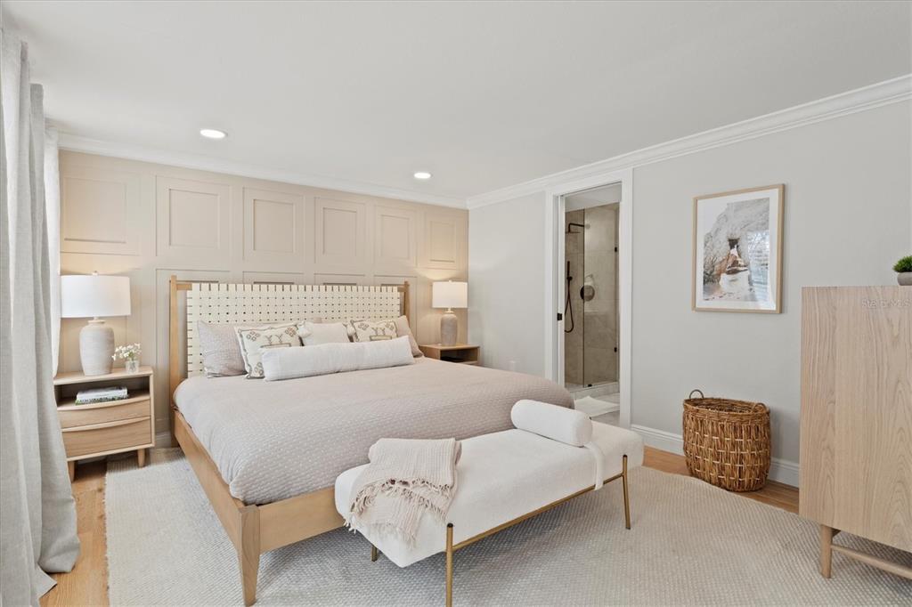 A bedroom features a paneled accent wall, a king bed, and an attached bathroom — 326 S LIME AVENUE, SARASOTA, FL