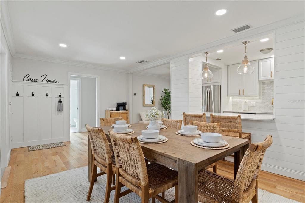 A dining room with a wooden table, wicker chairs, and an adjacent kitchen with white cabinetry — 326 S LIME AVENUE, SARASOTA, FL