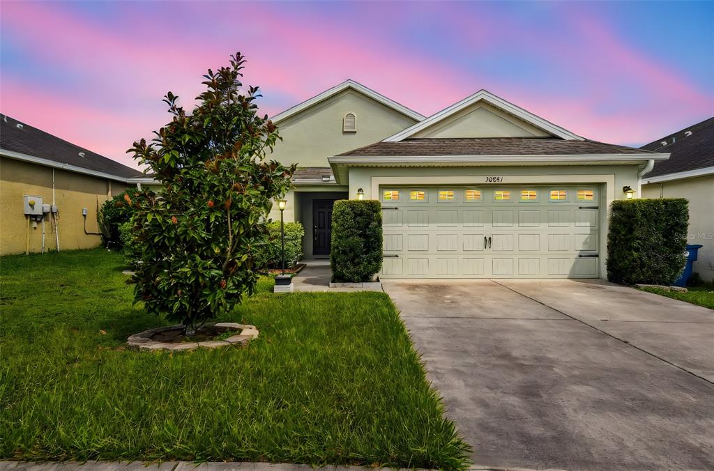 An aerial view shows a kidney-shaped swimming pool next to a pond and golf course — 30821 WATER LILY DRIVE, BROOKSVILLE, FL