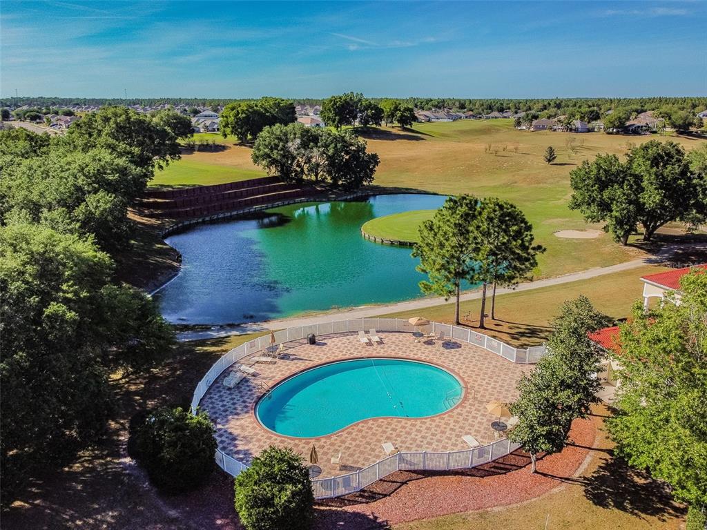 A single-story house with a light green exterior, a two-car garage, and a front lawn — 30821 WATER LILY DRIVE, BROOKSVILLE, FL