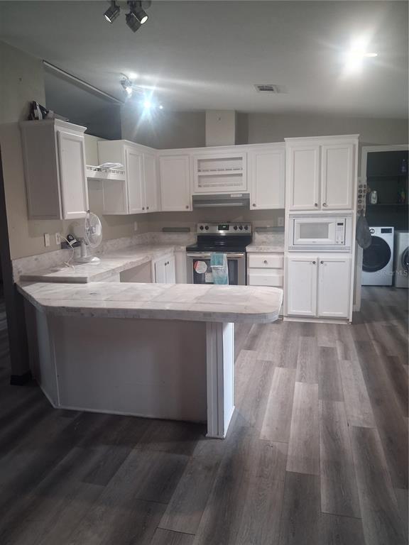 A kitchen with white cabinets, light countertops, and gray wood-look flooring — 8500 NW 10TH TERRACE, OCALA, FL
