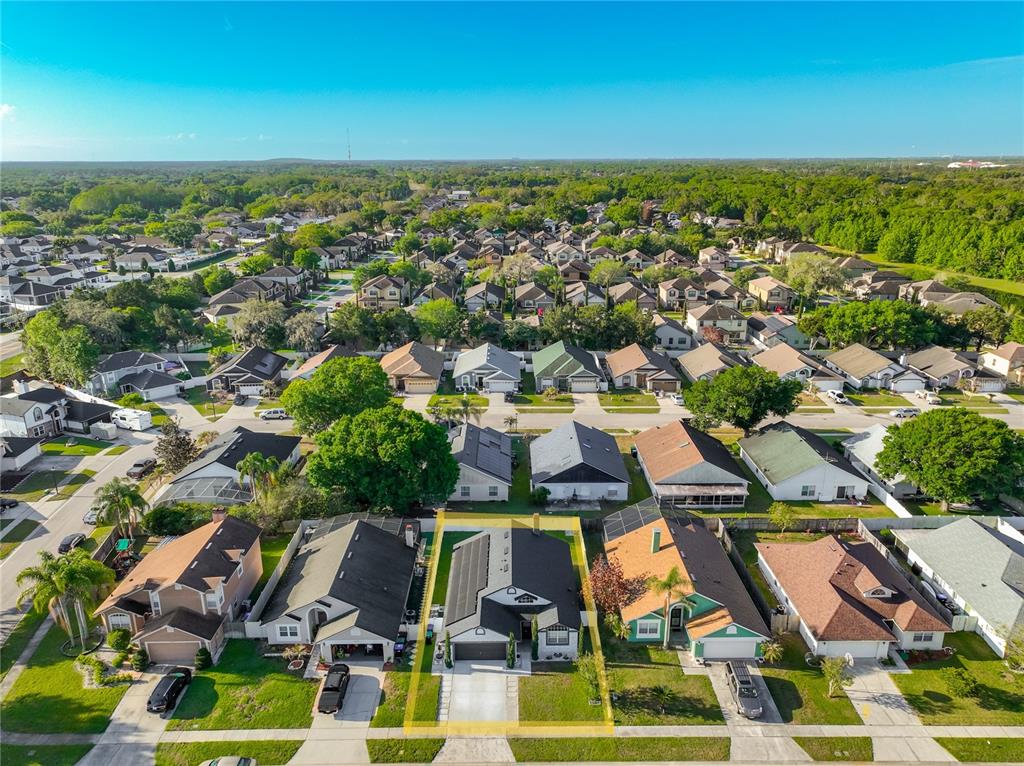 An aerial view shows a suburban neighborhood with a highlighted single-family home in the foreground — 10052 SANDBAR STREET, ORLANDO, FL