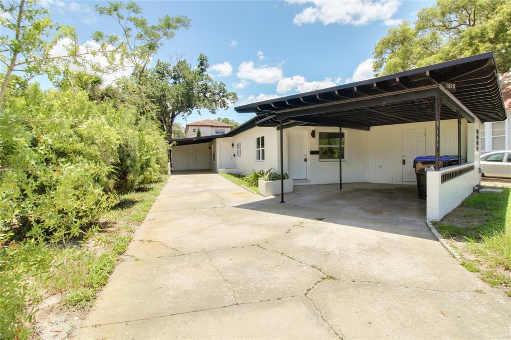 A white house with a large black carport and a concrete driveway under a blue sky — 1618 INDIANA AVENUE, WINTER PARK, FL