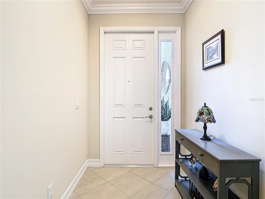 A foyer features a white front door with a sidelight, tile flooring, and a console table — 4935 MARBLE SPRINGS CIRCLE, WIMAUMA, FL
