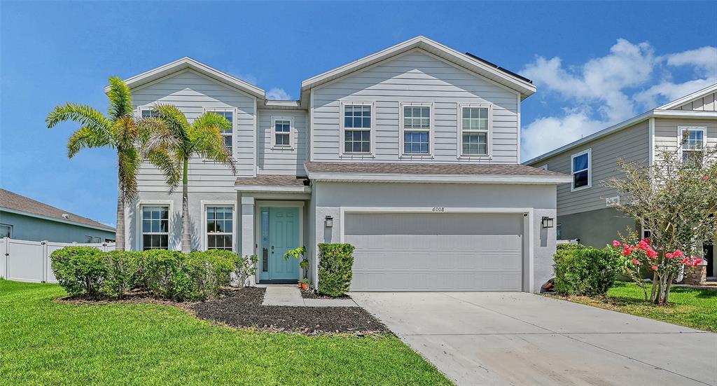 A two-story house with light gray siding, a two-car garage, and a palm tree — 6008 113TH TERRACE E, PARRISH, FL