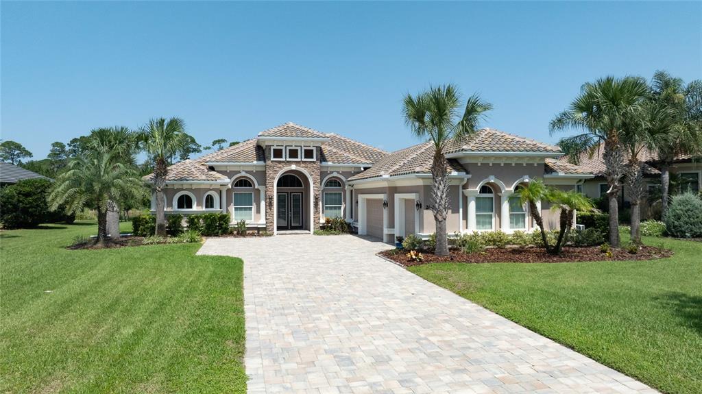 A single-story house with a stone facade, arched windows, and a paved driveway — 206 WILLOW OAK WAY, PALM COAST, FL