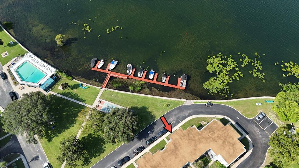 An aerial view shows a building, parking lot, swimming pool, and a dock with boats — 151 N ORLANDO AVENUE UNIT 261, WINTER PARK, FL