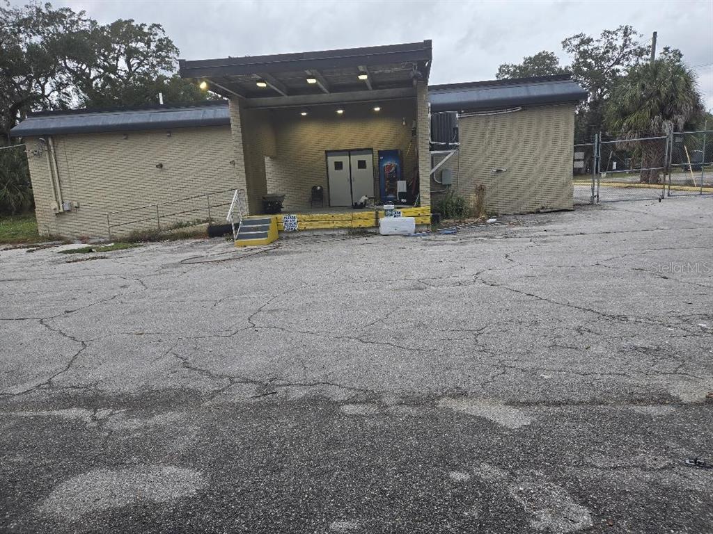 An exterior view of a single-story commercial building with a recessed entrance and paved lot — 10517 RIVERVIEW DRIVE, RIVERVIEW, FL