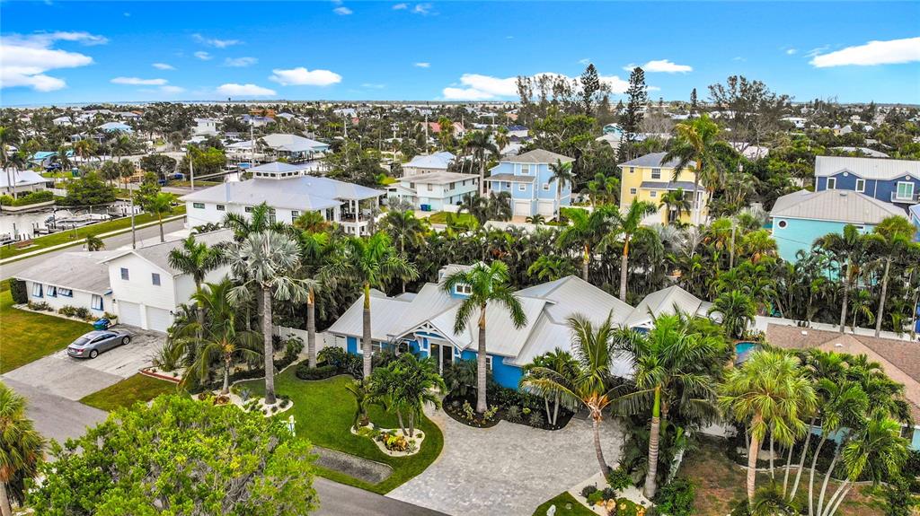 An aerial view shows a blue house with a metal roof surrounded by palm trees — 403 75TH STREET, HOLMES BEACH, FL