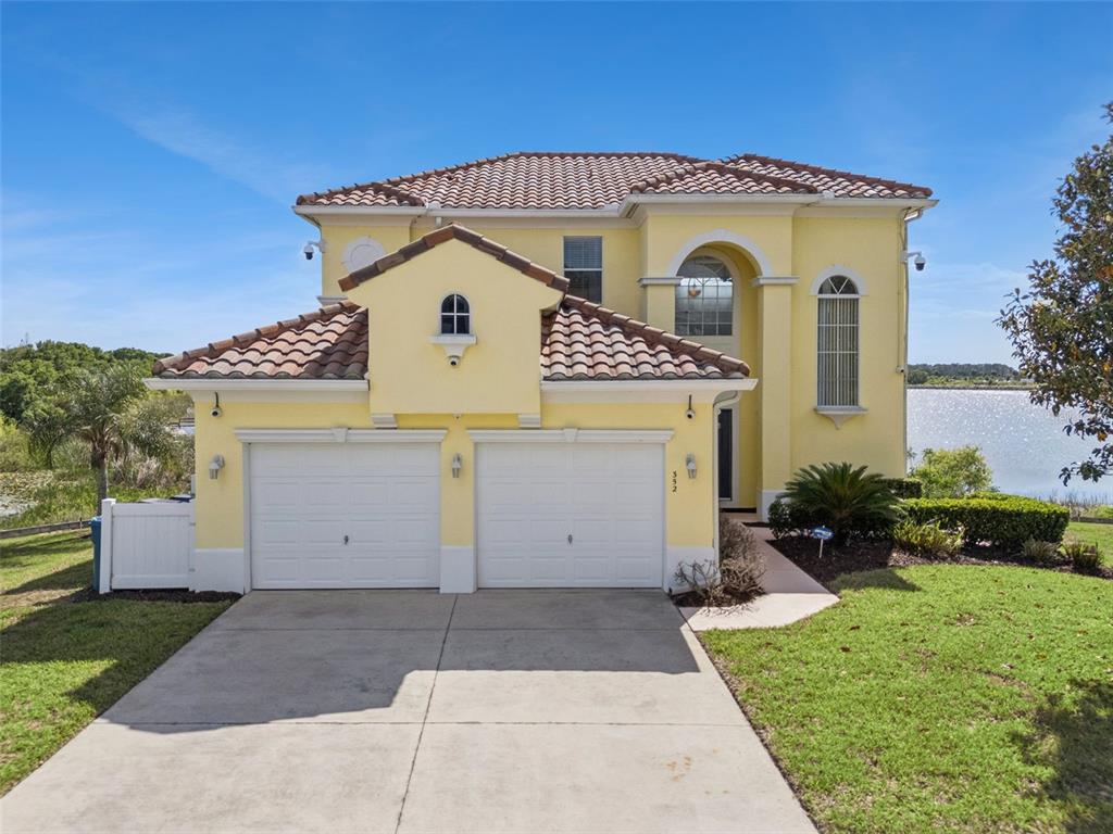 A screened-in pool and hot tub overlook a lake with a grassy shoreline — 352 CHEROKEE AVE, HAINES CITY, FL