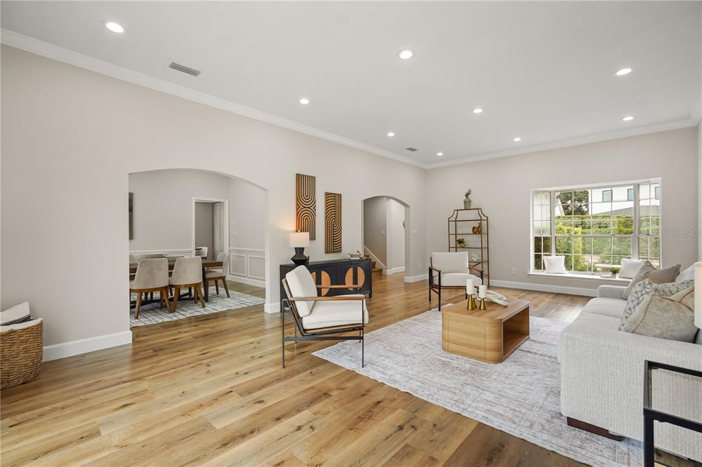 An empty room with light wood flooring, recessed lighting, and two arched doorways — 2186 COUNTRYSIDE CIRCLE N, ORLANDO, FL