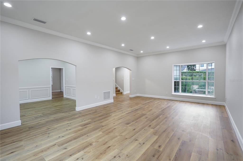 An empty room with light wood flooring, recessed lighting, and two arched doorways — 2186 COUNTRYSIDE CIRCLE N, ORLANDO, FL