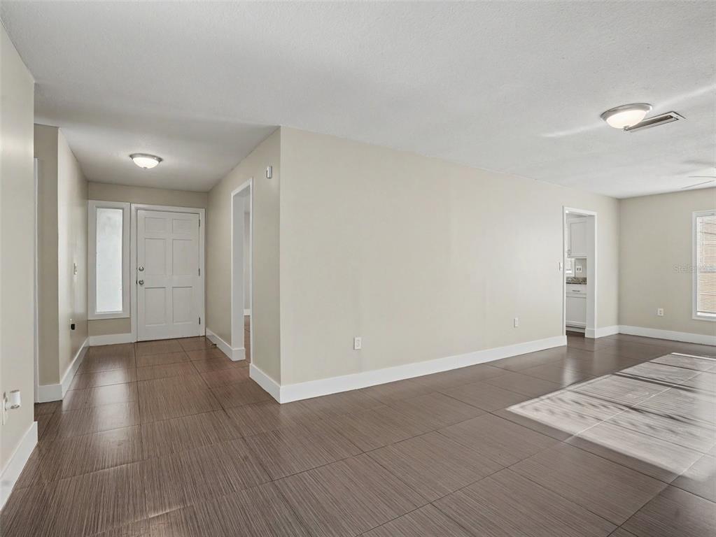 An entryway and living area with light-colored walls and dark wood-look tile flooring — 2938 NORTHBROOK LANE, LAKELAND, FL