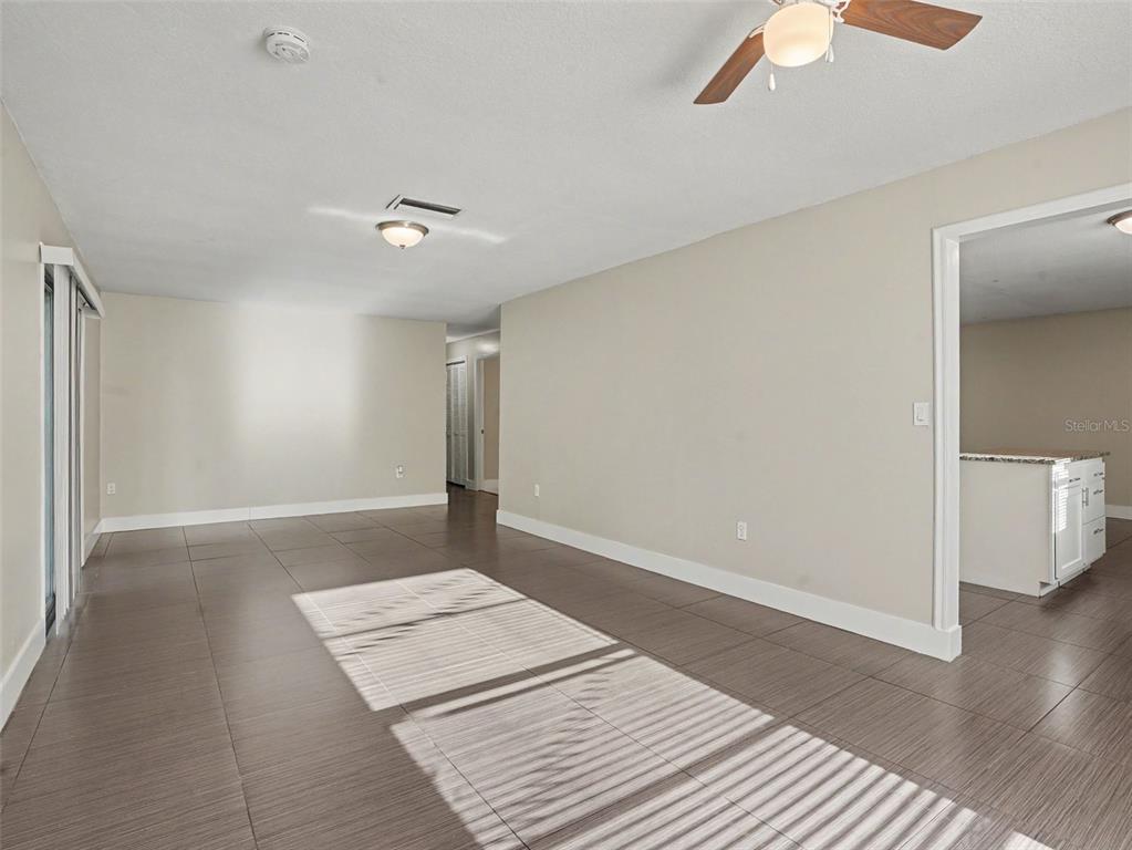 An interior view of a living area with tile flooring, a ceiling fan, and light-colored walls — 2938 NORTHBROOK LANE, LAKELAND, FL