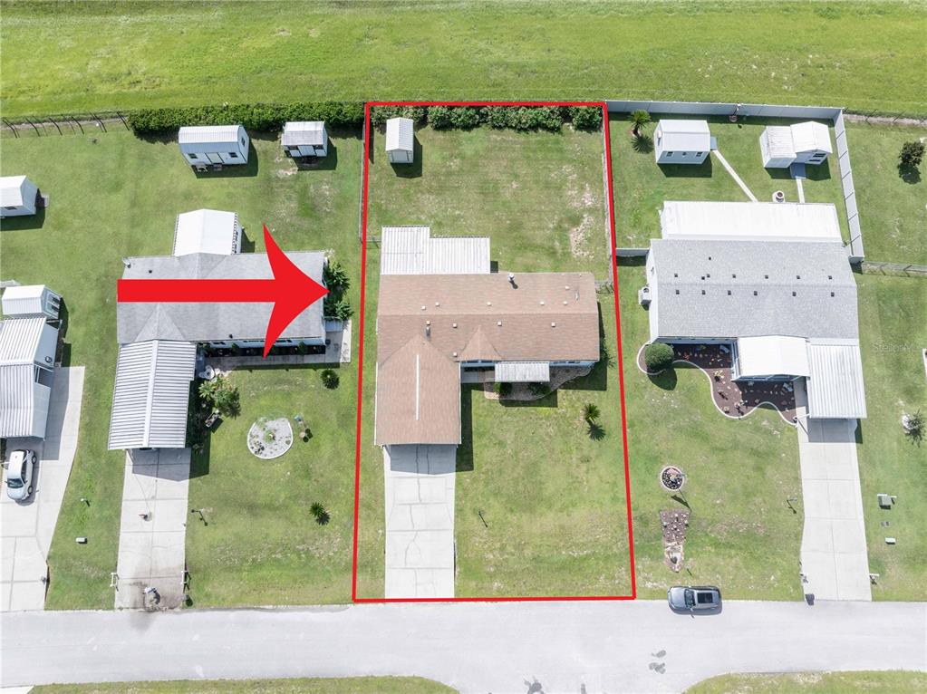 An aerial view shows a residential house with a driveway and backyard on a lot — 13259 SE 49TH COURT, BELLEVIEW, FL