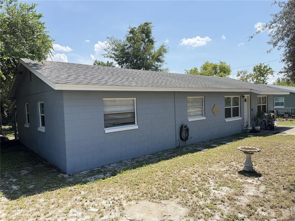 A single-story gray concrete block house with a shingled roof and a front yard — 4180 POINSETTIA AVENUE, MOUNT DORA, FL