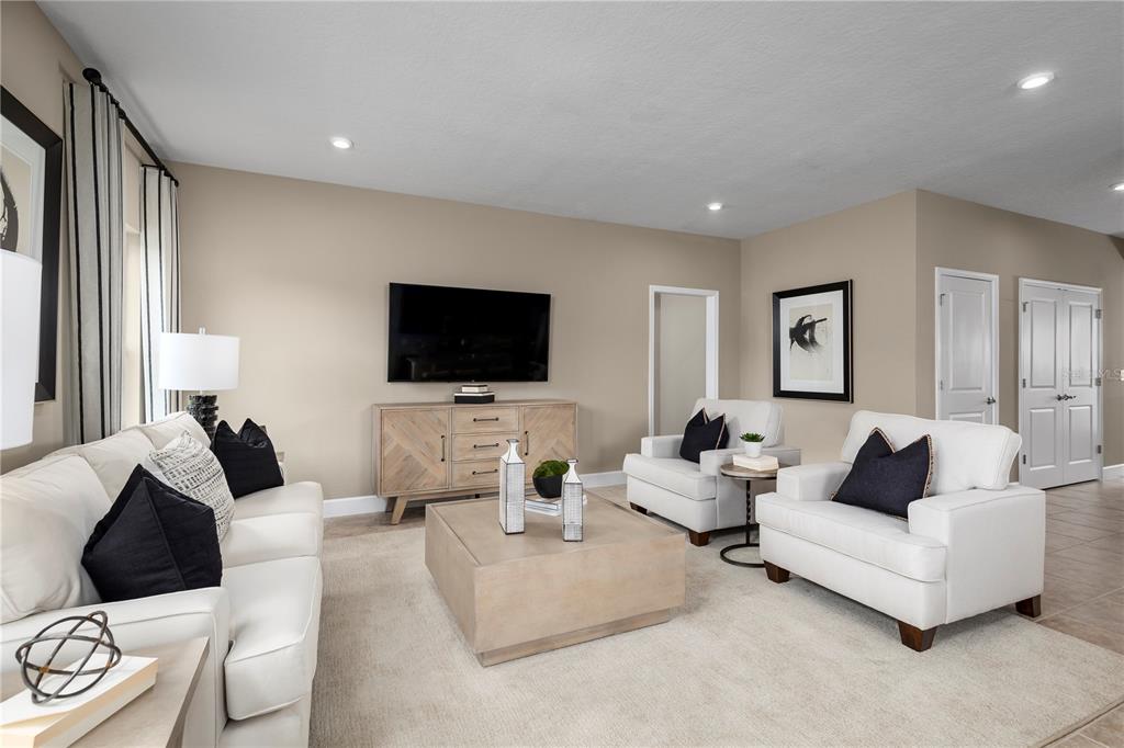A living room features white sofas and armchairs, a wooden media console, and a square table — 291 PRICKLY PEAR COURT, LADY LAKE, FL