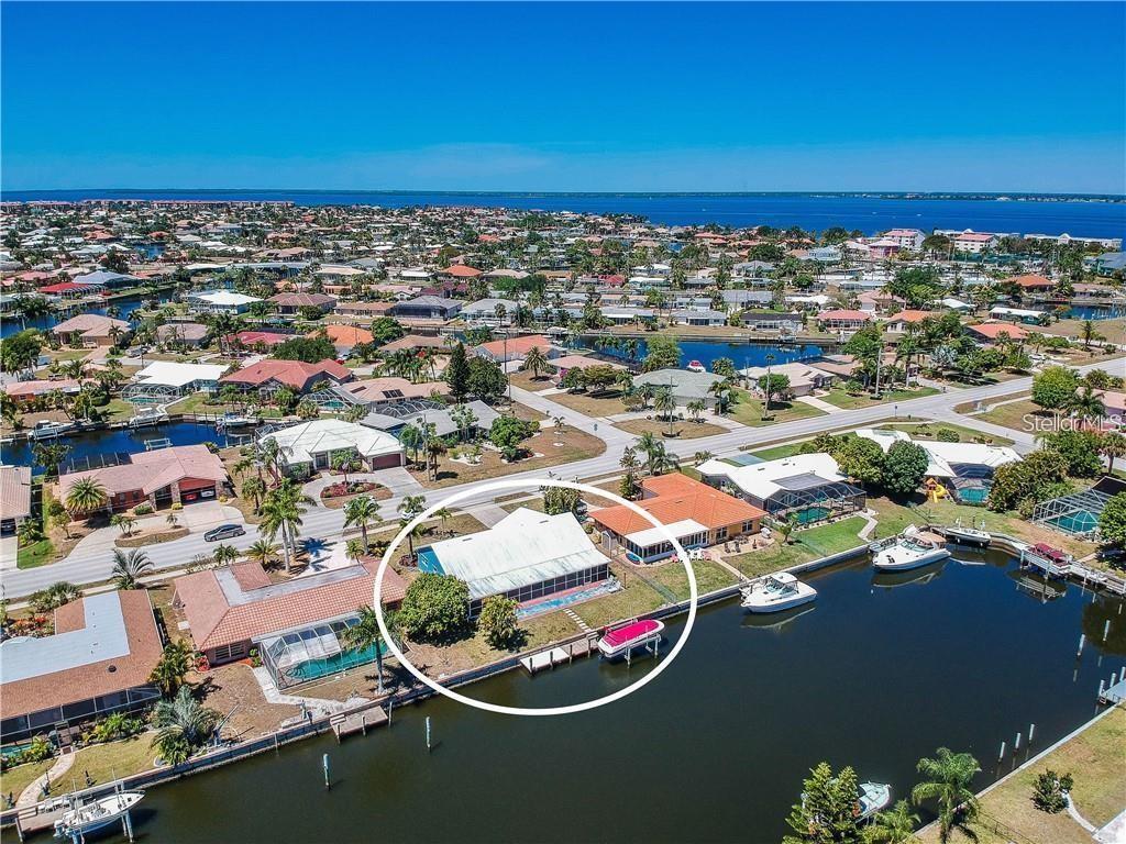 An aerial view shows a waterfront house with a screened pool enclosure and a boat dock — 416 BAL HARBOR BOULEVARD, PUNTA GORDA, FL