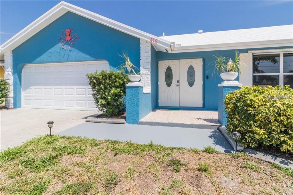 A blue house with a white garage door, double front doors, and a metal roof — 416 BAL HARBOR BOULEVARD, PUNTA GORDA, FL