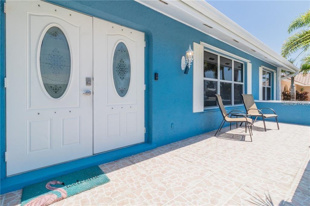 A blue exterior wall features double front doors with oval glass inserts and a tiled porch — 416 BAL HARBOR BOULEVARD, PUNTA GORDA, FL