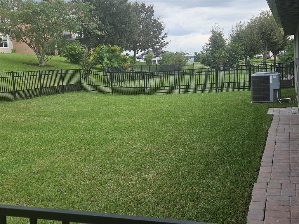 A fenced backyard with a screened patio attached to a single-story house — 4222 JULIANA LAKE DRIVE, AUBURNDALE, FL