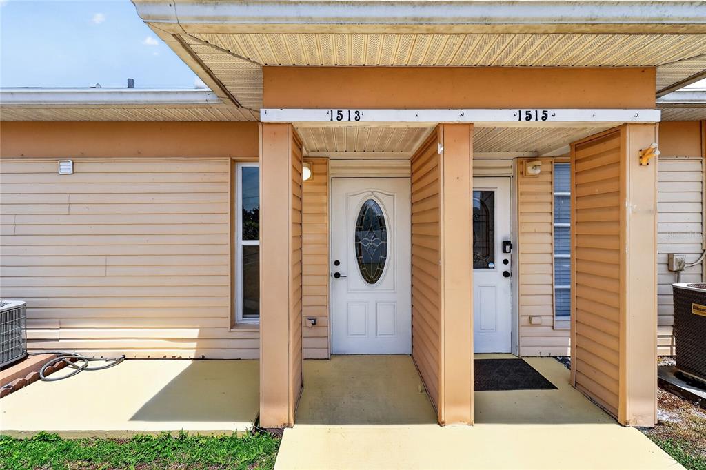 The exterior of a duplex features two adjacent front doors under a covered porch — 1513 CLUB CIRCLE UNIT 1513, LAKESHORE, FL