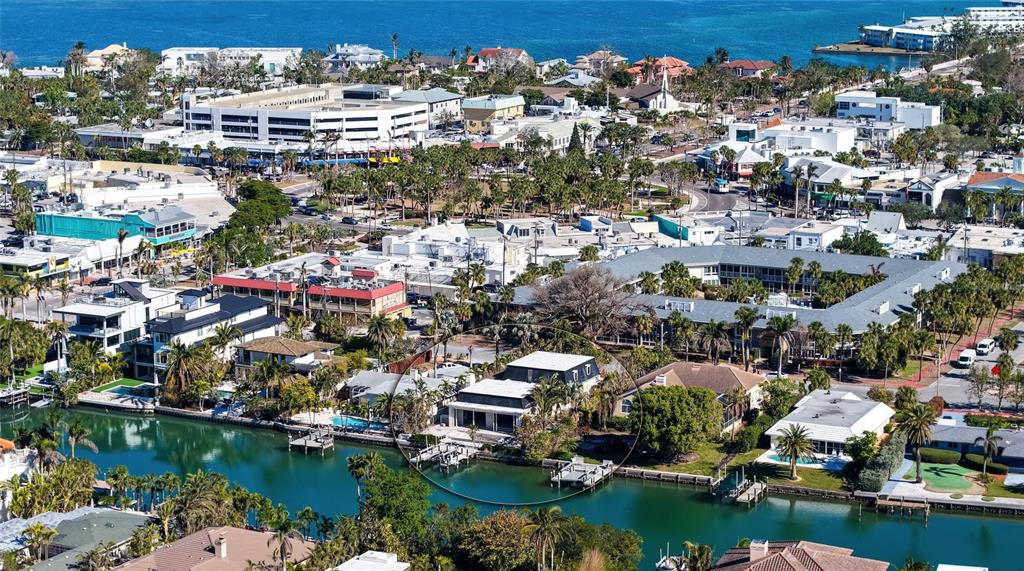 An aerial view shows a waterfront house with a pool and dock along a canal — 515 S WASHINGTON DRIVE, SARASOTA, FL