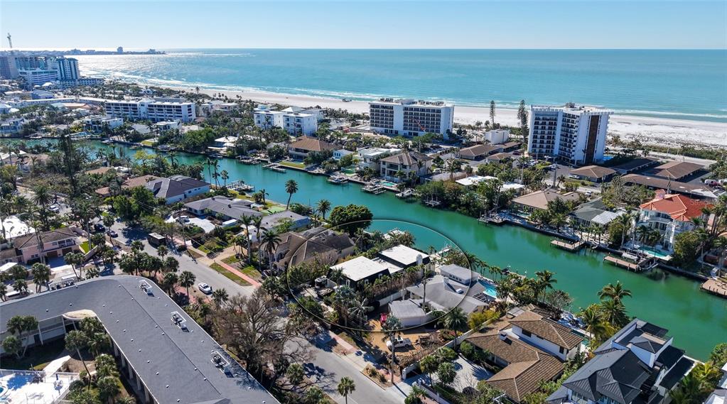 An aerial view shows a waterfront residential property with a pool and canal access — 515 S WASHINGTON DRIVE, SARASOTA, FL