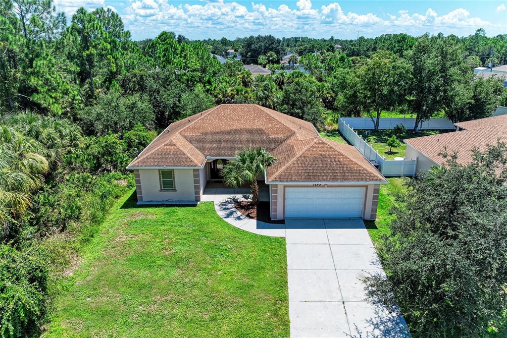 An aerial view of a single-story house with a brown roof and a concrete driveway — 3190 BAY CITY TERRACE, NORTH PORT, FL