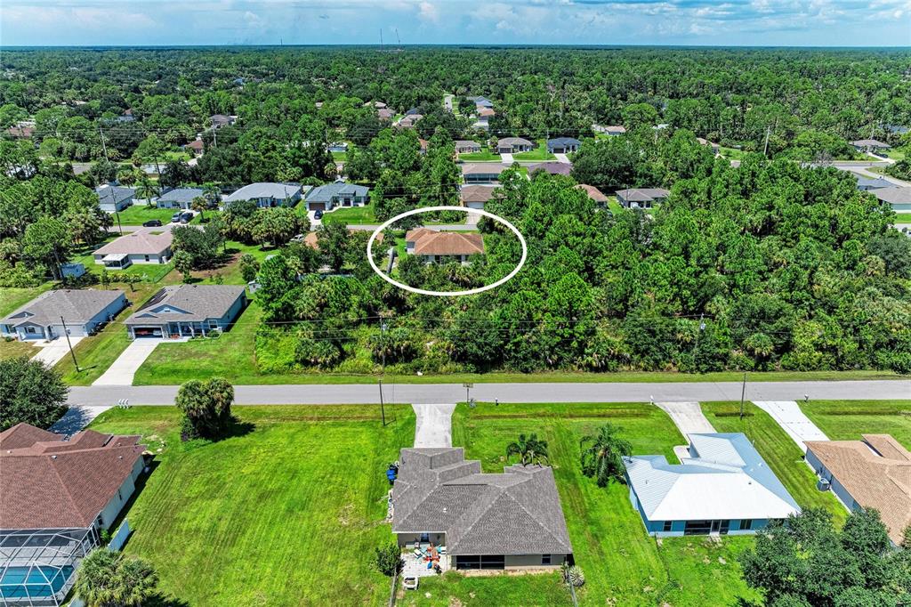 An aerial view shows a residential neighborhood with a house circled in the background — 3190 BAY CITY TERRACE, NORTH PORT, FL