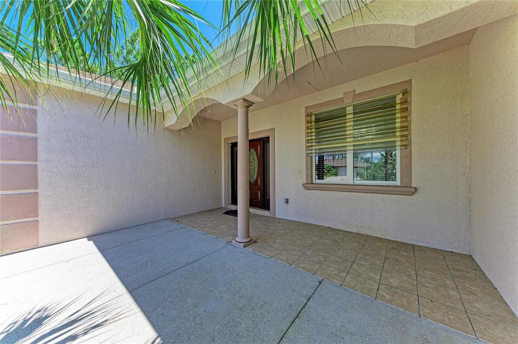 A covered entryway features a tiled porch, a single support column, and a front door — 3190 BAY CITY TERRACE, NORTH PORT, FL