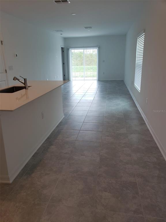 A modern kitchen features white cabinets, stainless steel appliances, and a central island with a sink — 757 REGGIE ROAD, WINTER HAVEN, FL