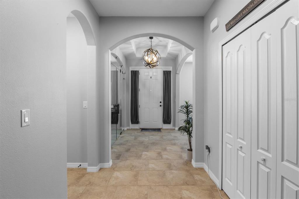 A tiled entryway features an arched ceiling, a globe pendant light, and white paneled doors — 230 BROAD STREET, WINTER HAVEN, FL